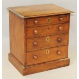 A walnut miniature chest of four long graduated drawers with brass mounted locks (one missing), on