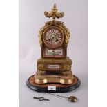 An English gilt metal cased mantel clock with pink, gilt and floral spray dial and panels, and Roman