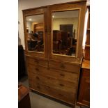 A late 19th century walnut linen press, the upper section fitted trays and enclosed mirror doors