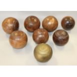 Seven lignum vitae bowling woods and another similar gold painted bowling wood