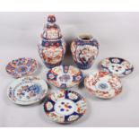 Six Imari plates of various designs, and a similar pair of vases (one with cover missing)