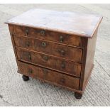 A George III walnut and banded chest of four graduated long drawers with brass drop handles, on