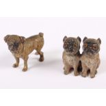 An Austrian miniature cold painted bronze model of a standing pug and a similar pair of seated pugs