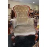 A Victorian carved mahogany showframe armchair, upholstered in a mushroom velour, on cabriole scroll