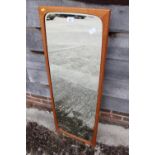 A 1960s teak framed wall mirror, plate 14" x 43"