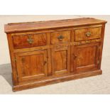 An antique oak, ash, elm and chestnut dresser base, fitted three drawers with brass handle plates