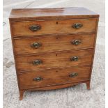 A George III mahogany chest of four graduated long drawers with oval brass handle plates and splay