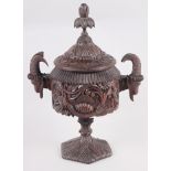 A carved softwood urn and cover with acanthus decoration and goat's head handles, 12" high (damages)