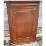 A Georgian oak corner hanging cupboard enclosed panelled door over one drawer, 33" wide x 19" deep x