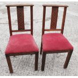A pair of carved oak standard chairs with Gothic splat backs, blind fret and drop-in seats, on