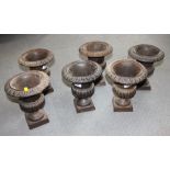 Six matched cast metal campana urns, on square bases, 9" high