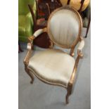 A Louis XVI design carved and gilt wood armchair, upholstered in a natural silk, on cabriole