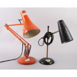 An orange "Anglepoise" lamp and a brass and black painted adjustable desk lamp