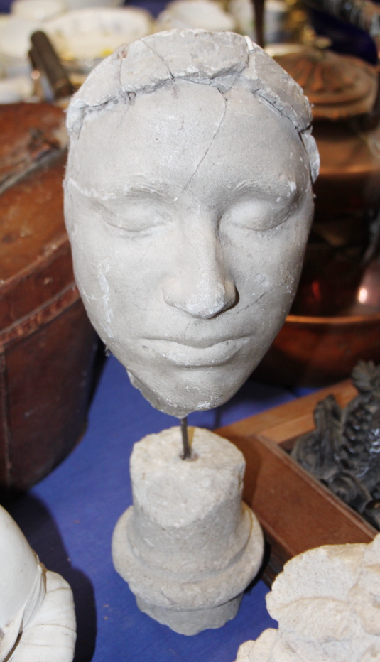 A 19th century plaster death mask of woman, on stone base (damages)