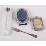An oval silver photograph frame, a miniature embossed silver photograph frame, a cut glass