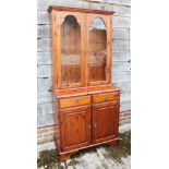 A pine dresser/china cabinet, the upper section enclosed two glazed doors over two drawers and