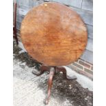 A Georgian mahogany circular tilt top table, on canon barrel turned column and tripod splay