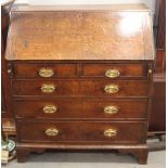 A Georgian provincial oak fall front bureau with fitted interior, drawers and pigeonholes over two