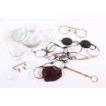 A gold plated lorgnette and various spectacles, lenses, pocket watch glasses, etc