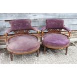 A pair of late Victorian rosewood and line inlaid low seat armchairs, upholstered in a purple