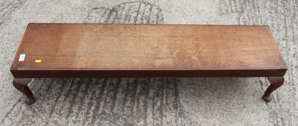 An oak low footstool, on cabriole supports, 48" wide