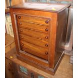 A mahogany collectors cabinet, fitted seven long graduated drawers enclosed glass door on plinth