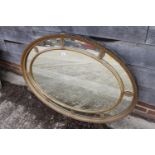 A late Victorian oval moulded and gilt framed wall mirror, plate 30 1/4" x 43"