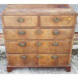 A late Georgian walnut and banded chest of two short and three long drawers with brass handles, on
