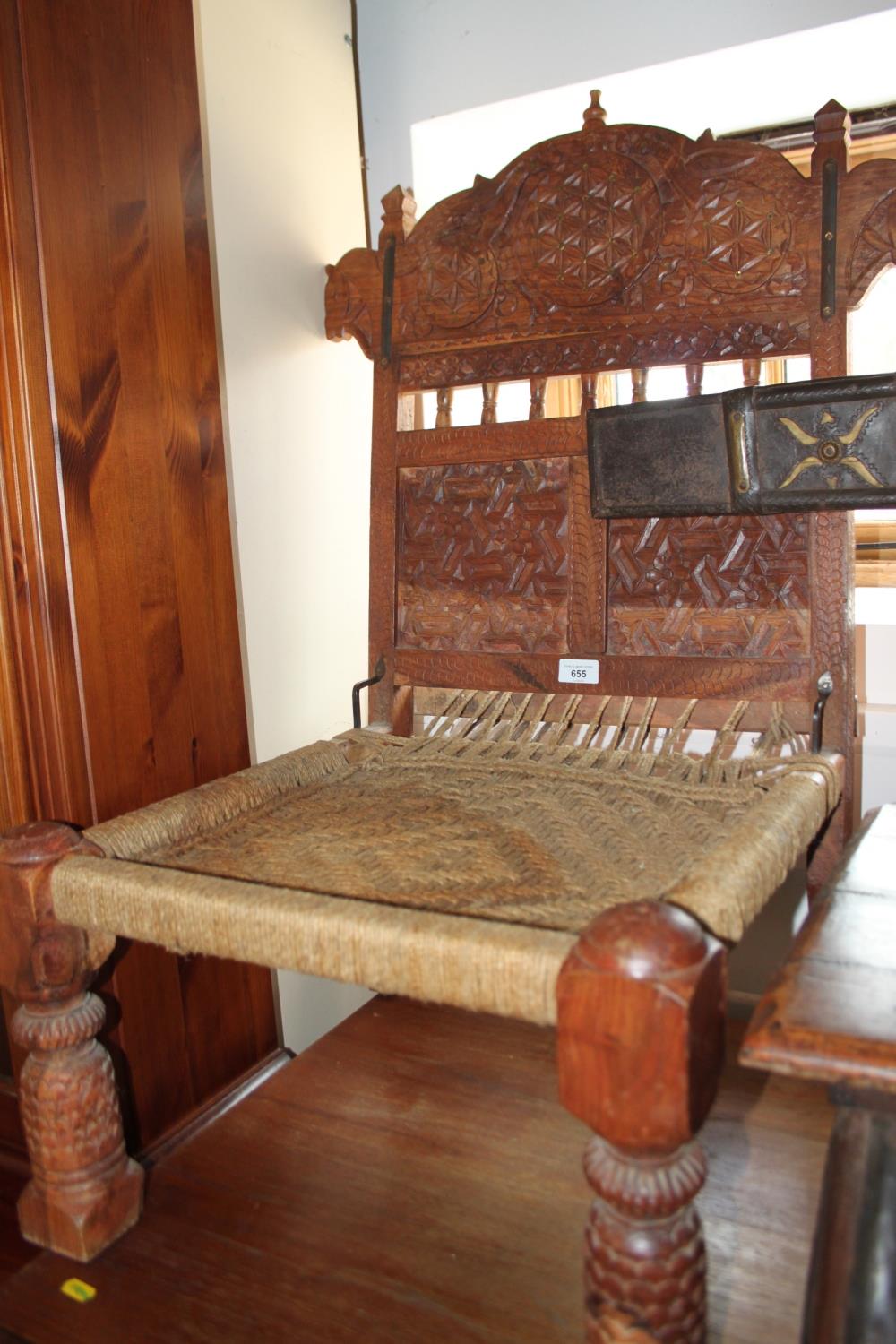 A pair of Indian sheesham low chairs with carved decorative backs and rush seats, on turned carved