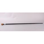 An ebonised walking cane with carved coquille nut finial formed as an Oriental gentleman, 36