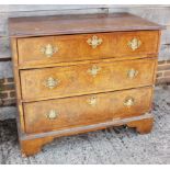 An 18th century walnut and banded chest of three long graduated drawers with brass bail handles