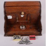 An early 20th century oak stationary cabinet with an associated glass inkwell and a number of dip