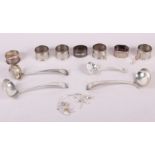Three silver napkin rings, four silver plated napkin rings with decorations, a silver sifter