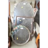 A circular framed wall mirror with relief flower and bevelled plate, 11 1/2" dia, two frameless