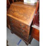 A walnut and banded fall front bureau with shaped fitted interior over four long drawers, on bracket