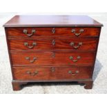 A George III mahogany chest of four long graduated drawers with gilt brass scroll handles, on