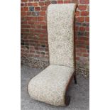 An early 20th century low seat nursing chair, button upholstered in a tapestry fabric, on scroll