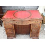 A mahogany and banded serpentine front double pedestal desk with red leather tooled lined top,