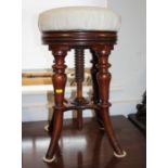 A 19th century walnut circular top piano stool with adjustable stem, on splay supports