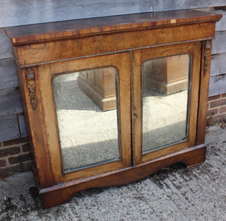 A late Victorian walnut and banded credenza/pier cabinet enclosed two arch top mirror panelled