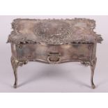 A silver jewellery box, in the form of a dressing table fitted one drawer and with embossed