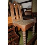 A 19th century oak Gothic design pierced panel back hall chair, on bobbin turned supports