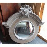 A circular wall mirror with grey painted frame