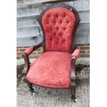 A Victorian carved walnut showframe open armchair, upholstered in a red figured velour, on turned