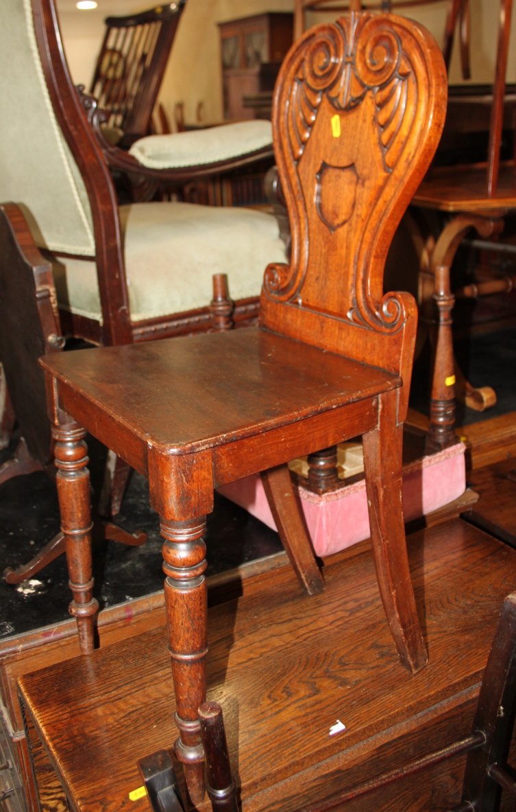 A George IV carved mahogany hall chair with scroll back and panel seat, on turned supports - Image 2 of 2