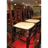 A pair of ebonised mahogany bedroom chairs with padded seats, on turned and stretchered supports