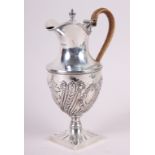 A silver water jug with embossed decoration and caned handle, 11.4oz troy approx