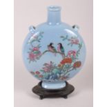 A Chinese moon flask with famille rose decoration of birds and flora, 9 1/2" high, with hardwood