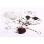 A gold plated lorgnette and various spectacles, lenses, pocket watch glasses, together with a number