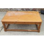 A pine low coffee table, on turned and stretchered supports, 44" long x 26" wide x 16" high